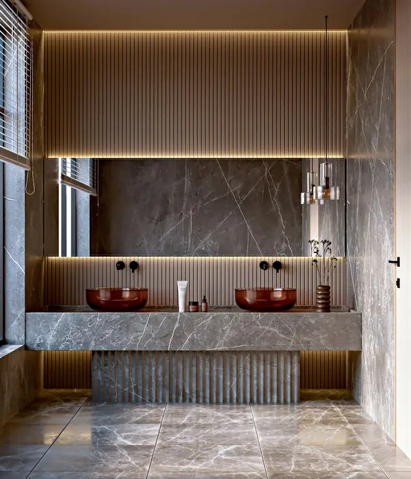 A dark marble spa room with twin basins and warm concealed lighting